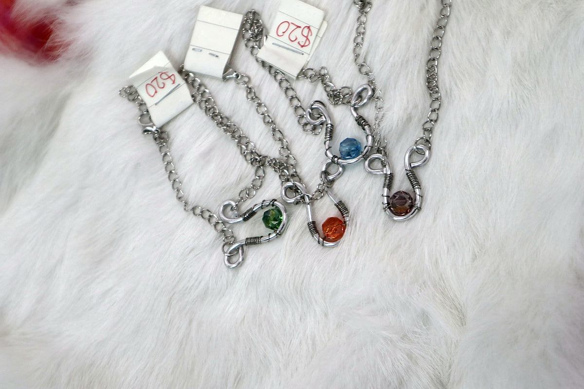 Four chain bracelets with green, orange, blue and amber beads set in twisted wire
