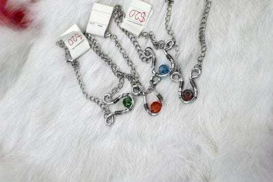 Four chain bracelets with green, orange, blue and amber beads set in twisted wire