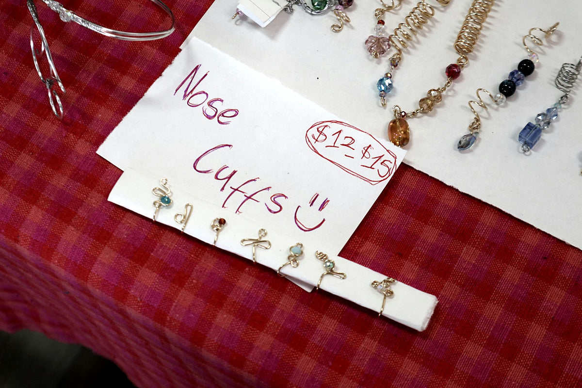 Handwritten sign for nose cuffs with small wire cuffs underneath