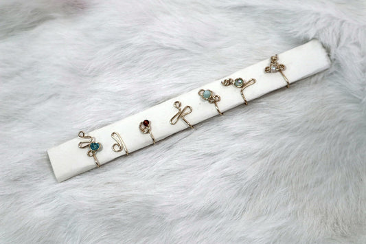 Row of small wire rings with beads laid on a white card